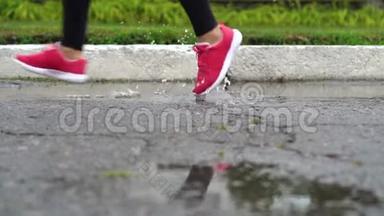 穿<strong>运动鞋</strong>的跑步者的腿。 运动女人在<strong>户外</strong>慢跑，踩在泥泞的水坑里。 单跑运动员在雨中奔跑
